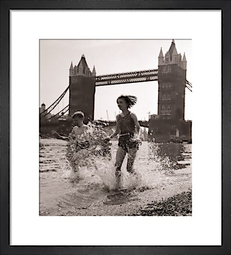 Children paddling on the foreshore below Tower Bridge by Mirrorpix